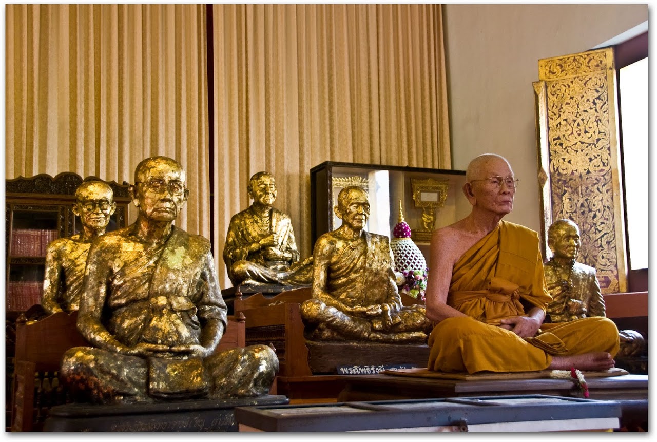 Monk sitting amidst golden monks